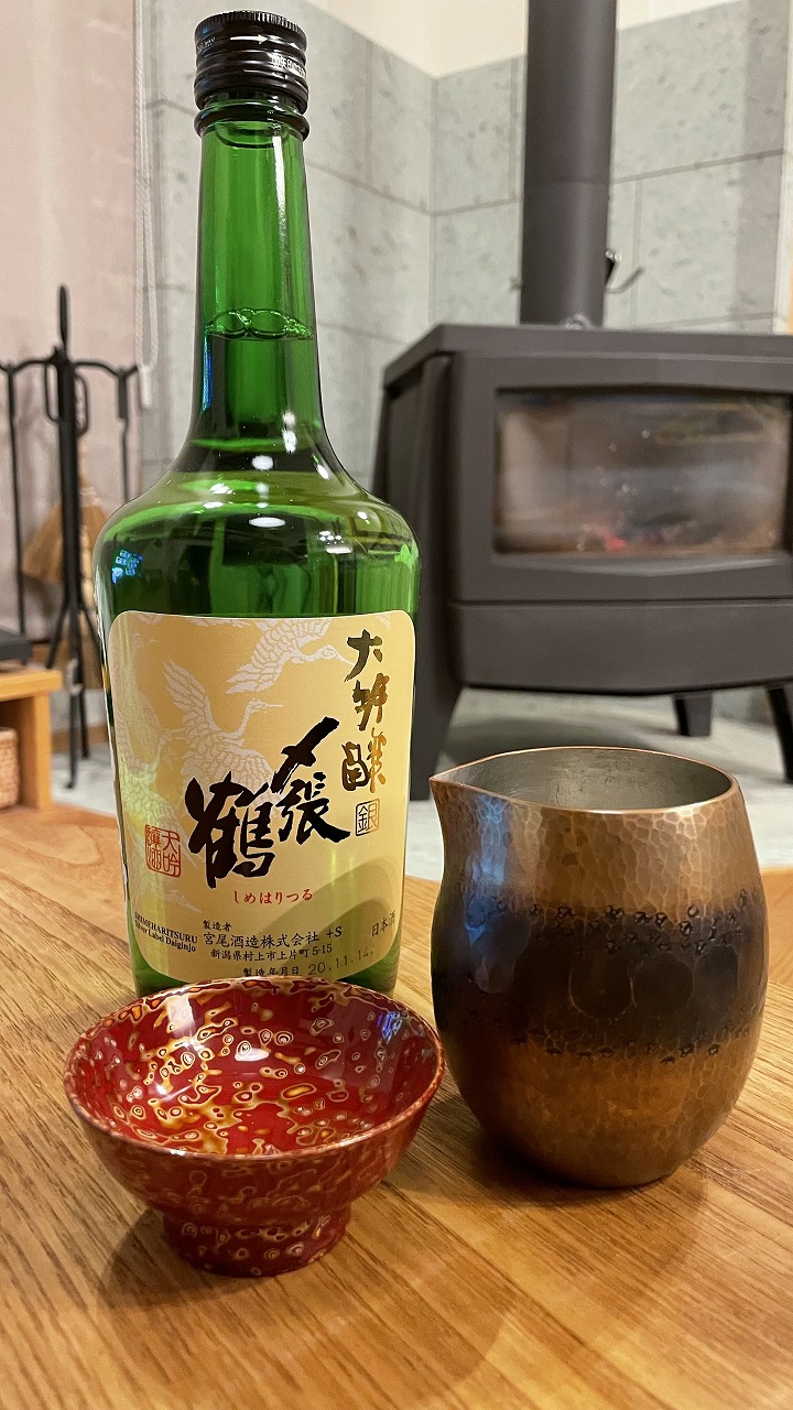 薪ストーブを背景に置いた日本酒