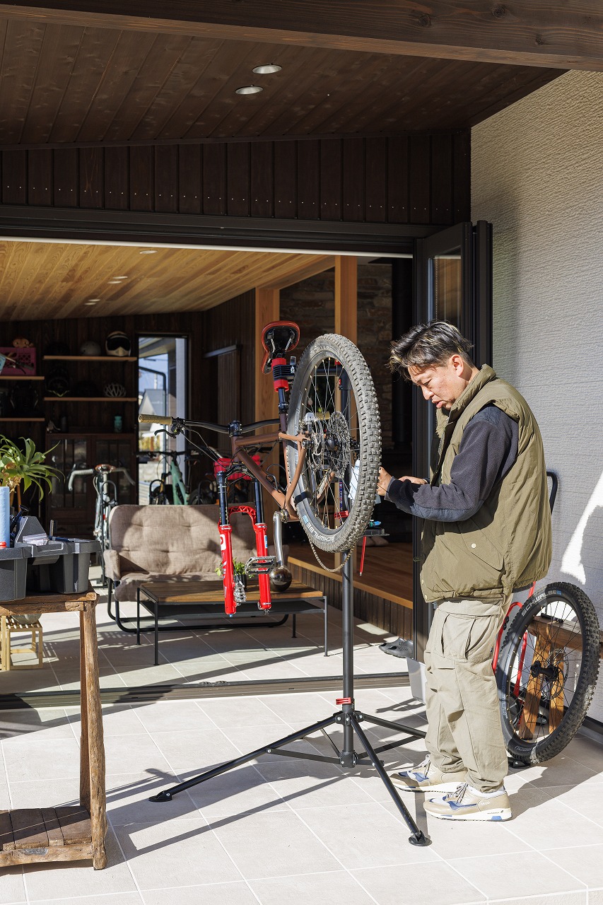 テラスで自転車をメンテナンスする男性